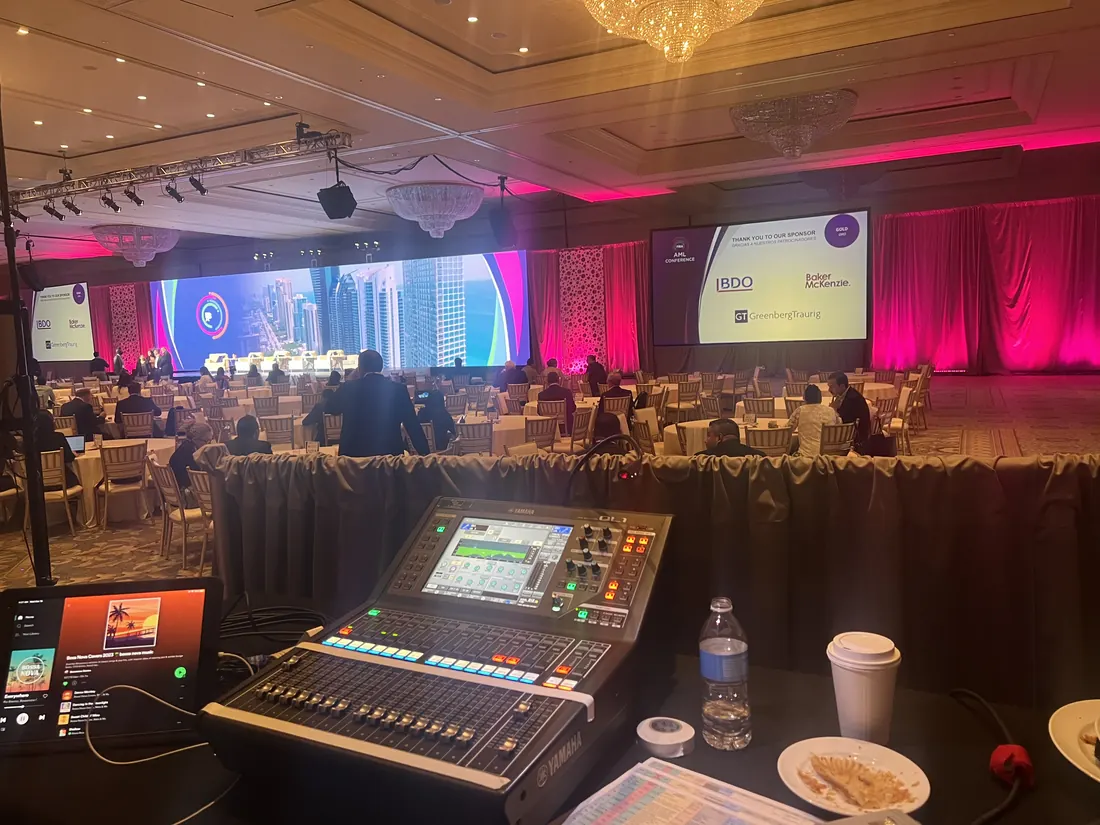 Digital audio console in front of an LED wall and projection screen at the InterContinental Miami